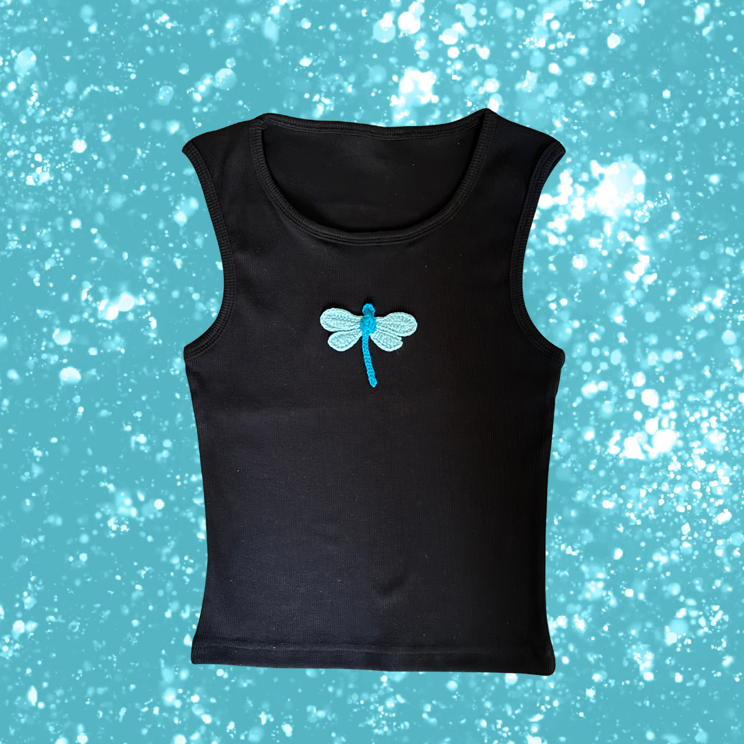 Black sleeveless shirt with a blue dragonfly design on a blue background with white specks, branded 'Carnation'.