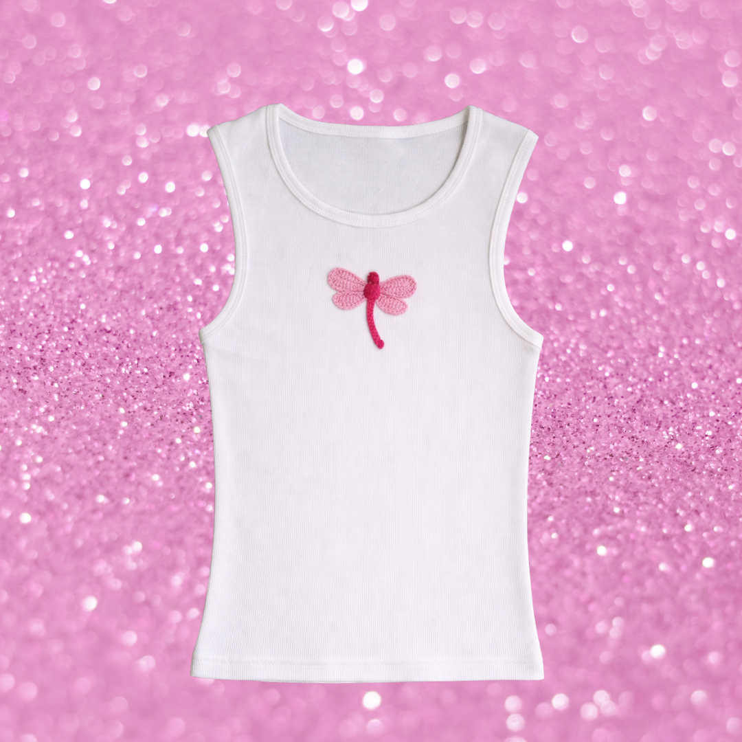 White tank top with a pink dragonfly design on a pink glittery background